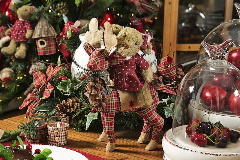 Em um canto da mesa, a ursa na garupa da rena encanta as crianças da casa.