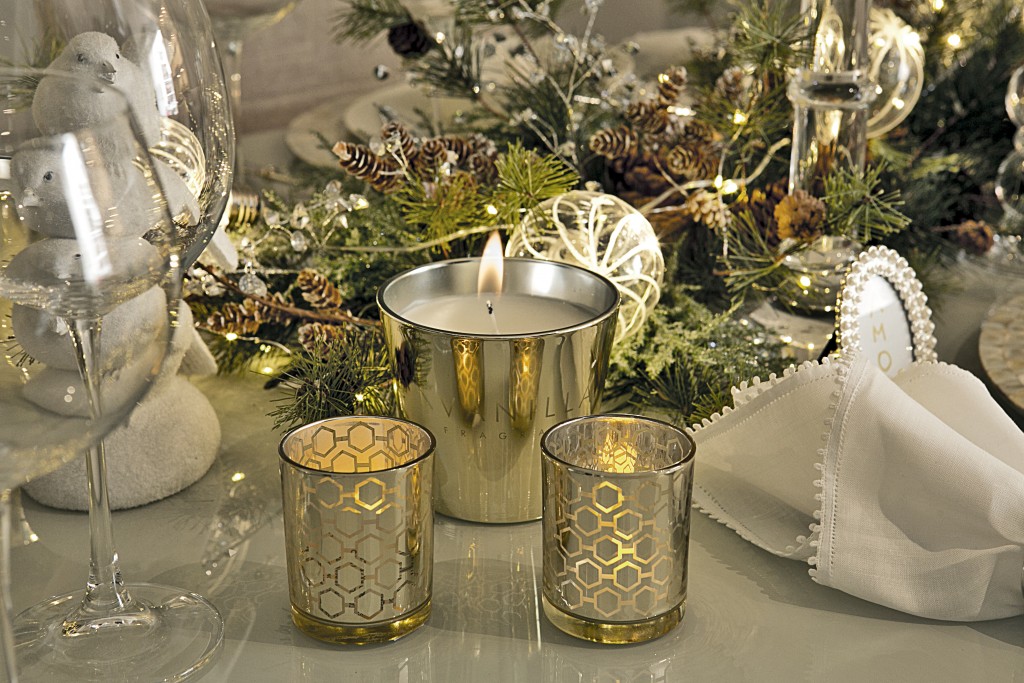 Nos cantinhos da mesa, detalhes com a vela de baunilha, que perfuma o ambiente, e dois copinhos iluminados por velas de rechaud (essas são de led, a pilha).
