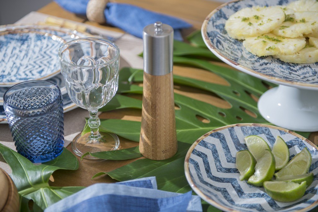 O copo bico de jaca azul entra no tom marinho, enquanto a taca de vidro Goblet serve de água a vinho sem frescura. Pratos de bolo em dois tamanhos mantem as frutas acima do mar de folhas. Pimenteiro do bambu. 
