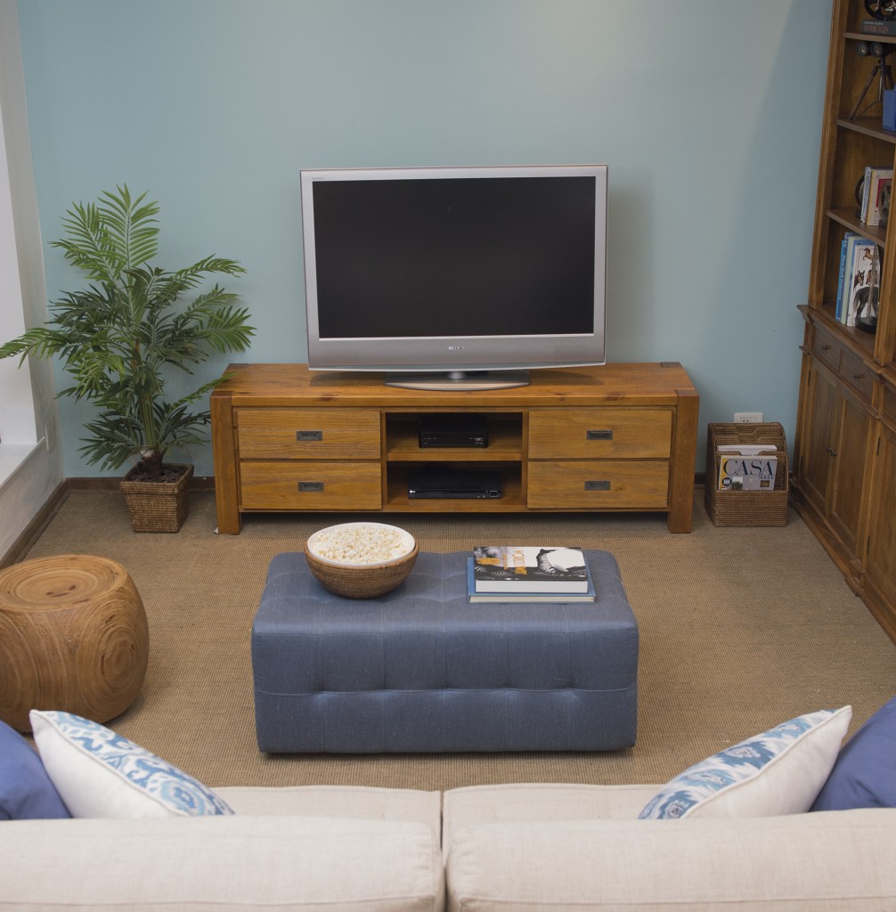 Na sala de TV, o pufe funciona coo mesa de centro e apoio para os pés.