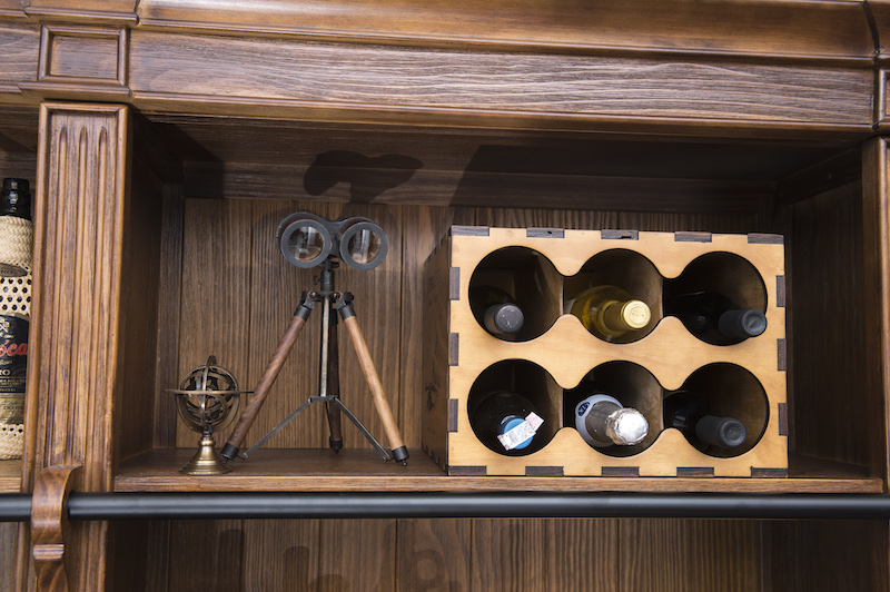 As garrafas de vinho ficam bem organizadas na caixa adega, com rótulos impressos nas laterais.