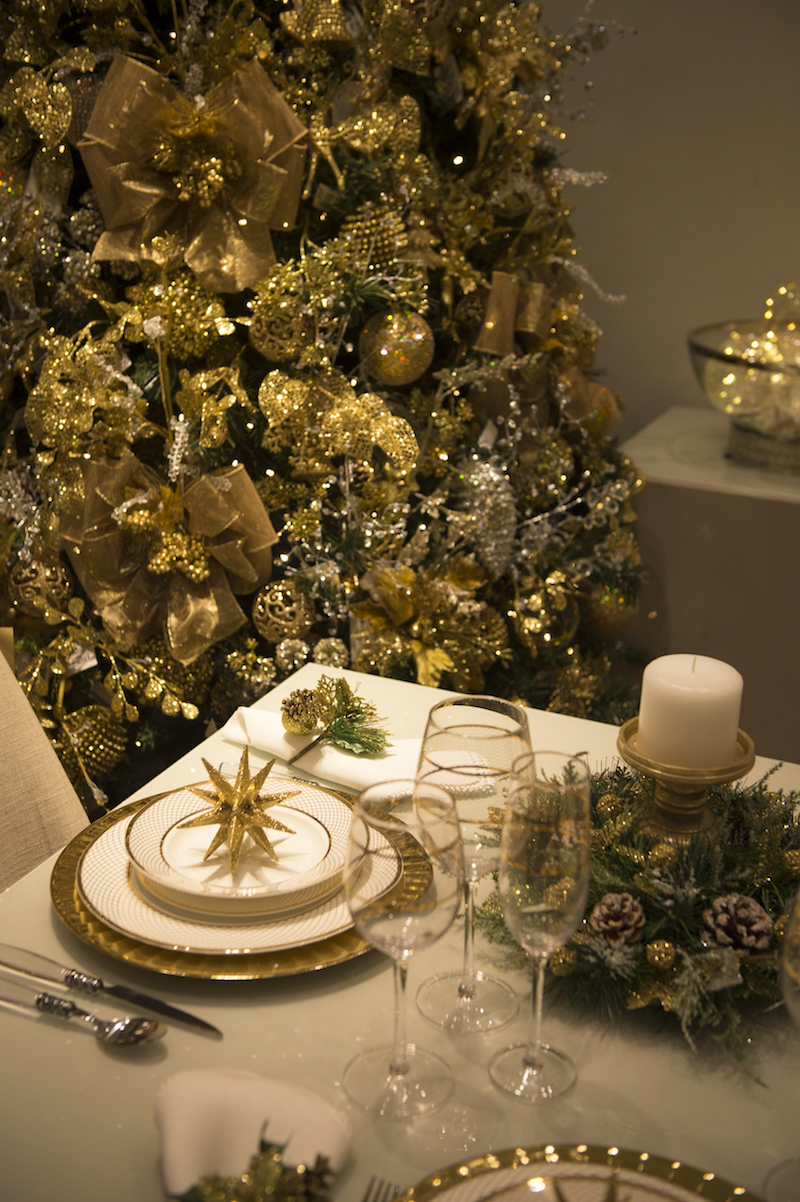 Além da árvore, a mesa entra nos tons da decoração de Natal, com taças e pratos com detalhes dourados.